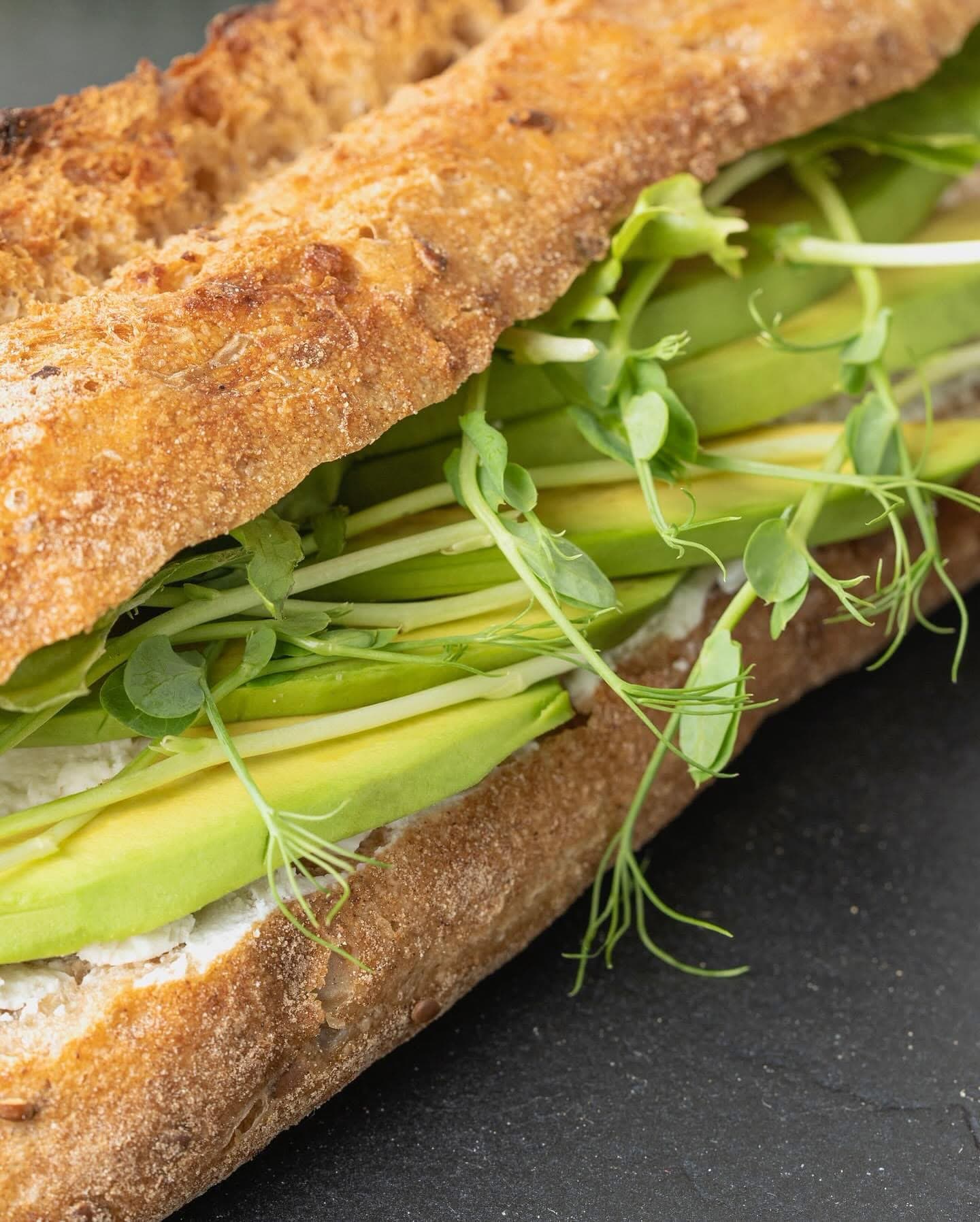 A baguette with avocado, cream cheese and microgreens