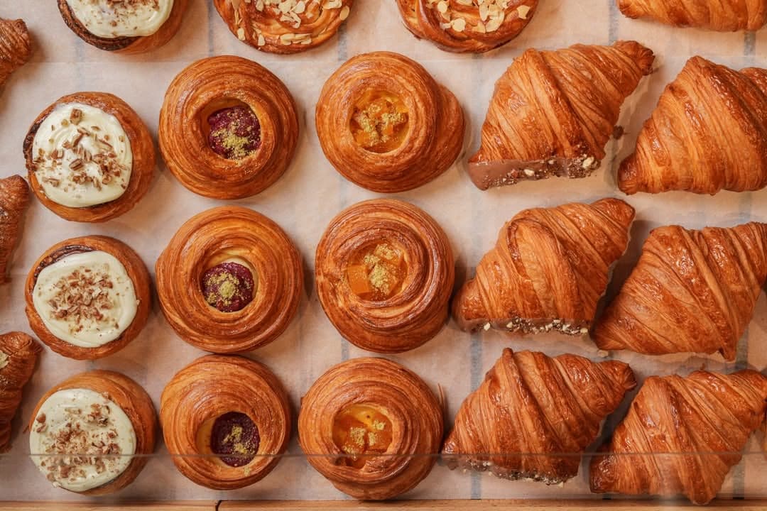 A display tray of croissants and pastry swirls