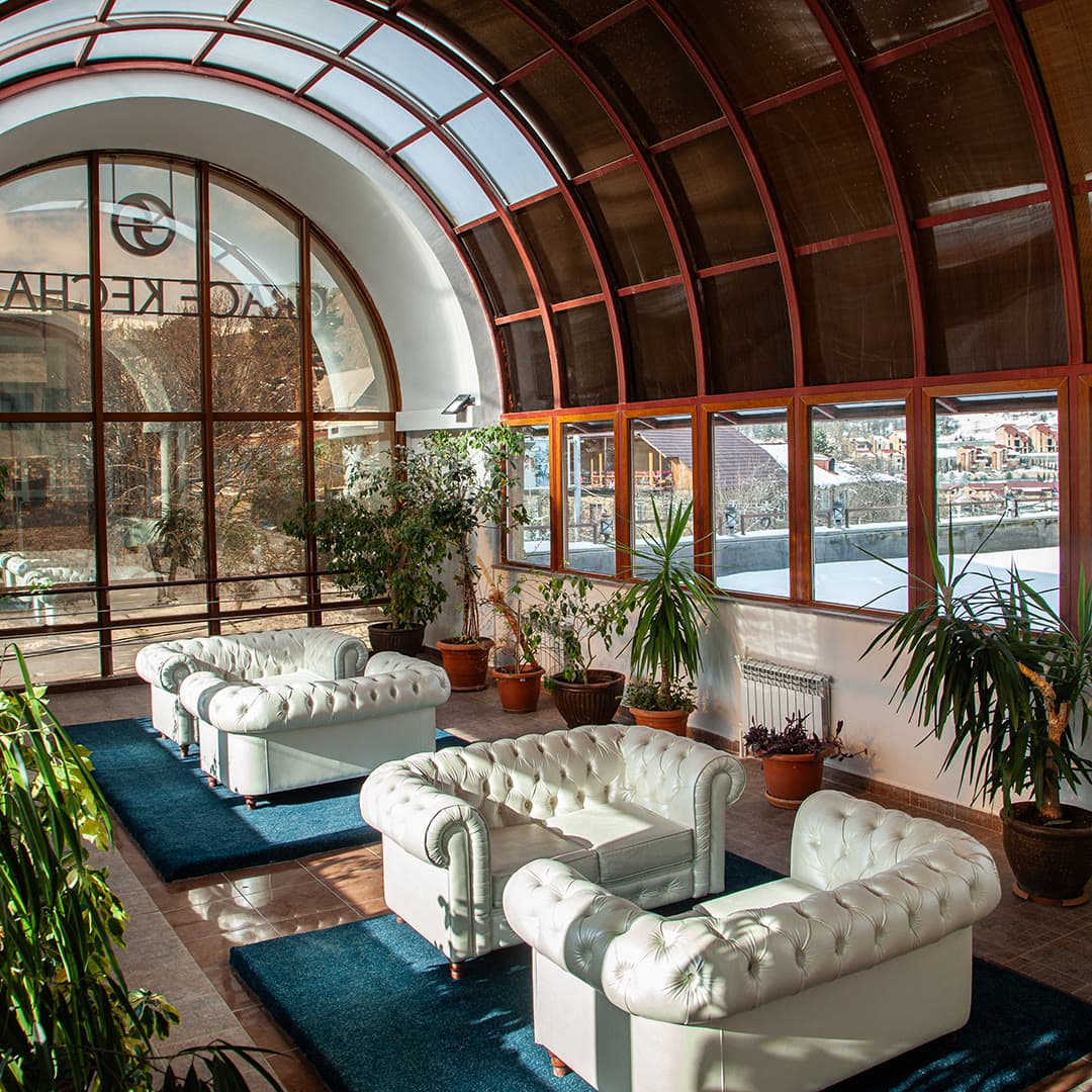 The hotel's atrium lounge with arched glazing and green plants