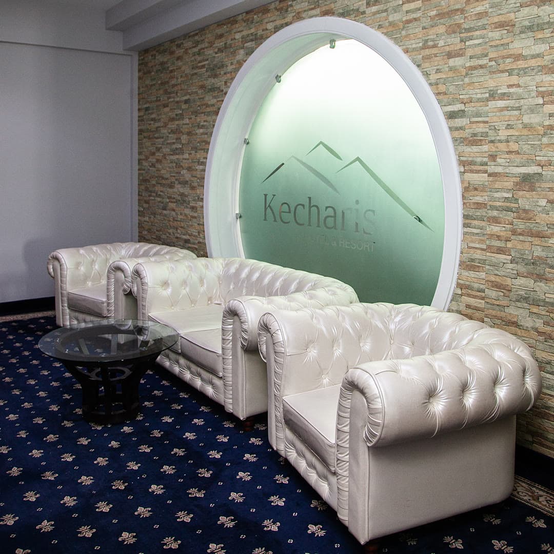 A lounge area with a lit niche and the Kecharis logo