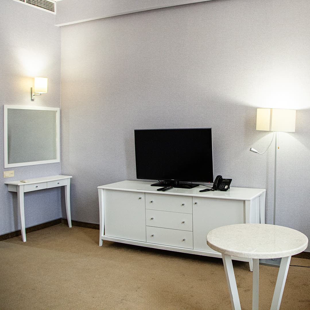 The TV, dresser and vanity area in a guest room