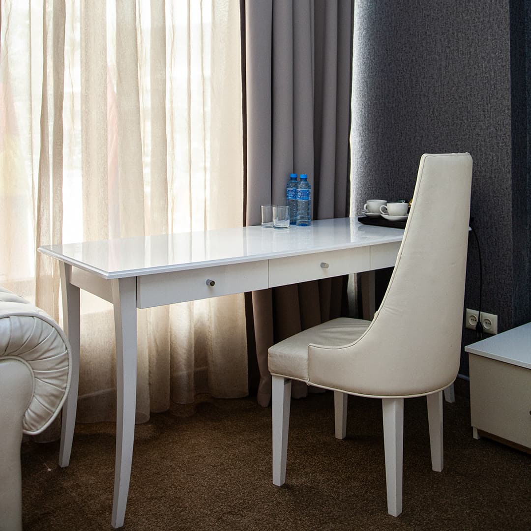 A desk by the window with a tea set in a hotel room