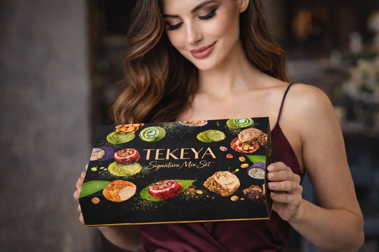 A woman in a burgundy dress holding a Tekeya Signature Mix Set gift box