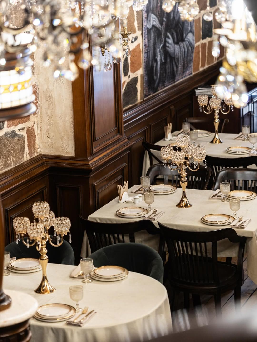 The restaurant's banquet hall with chandeliers, candelabras and white tablecloths
