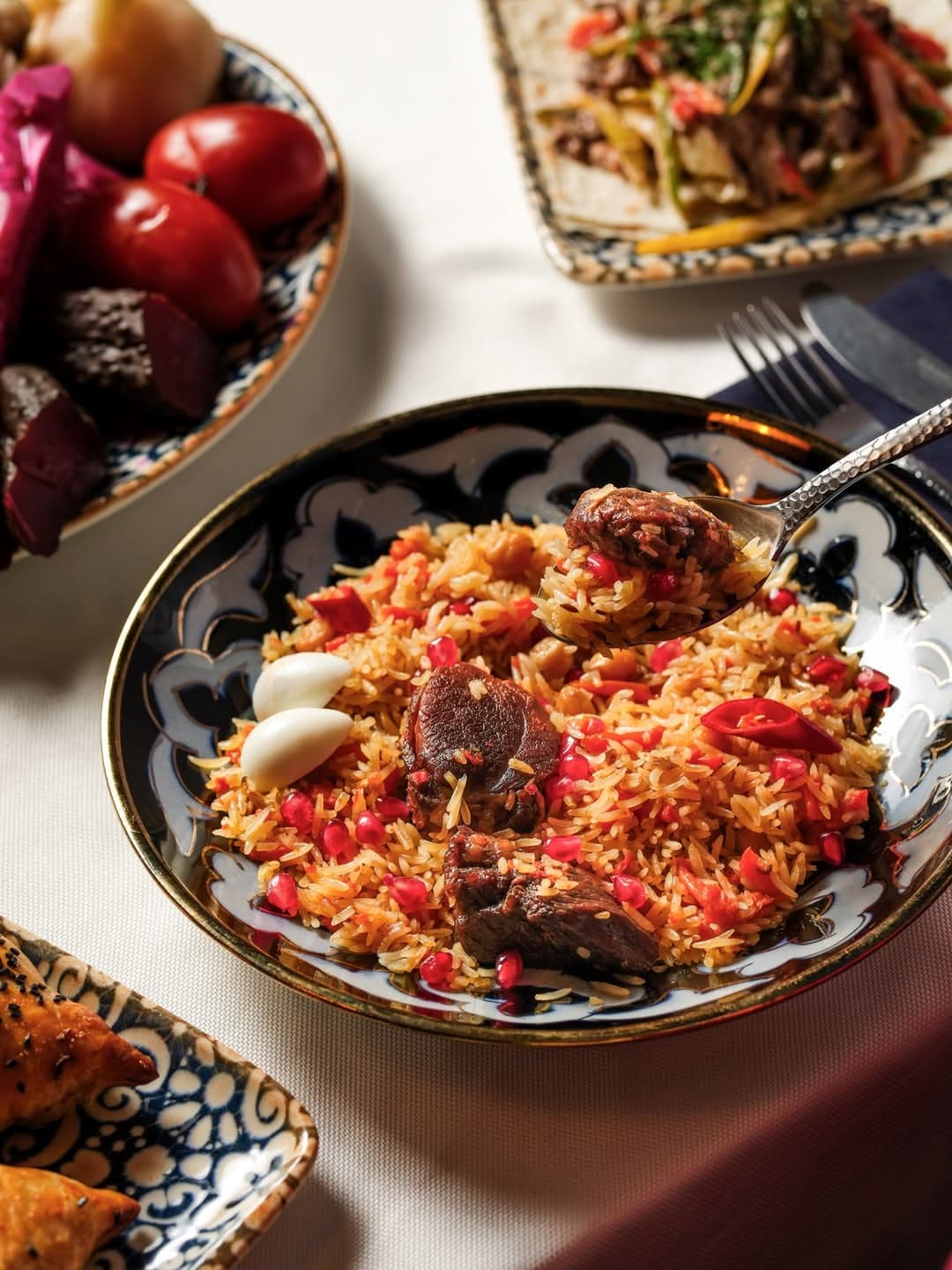 Lamb plov on an Uzbek lyagan dish with fruit beside it